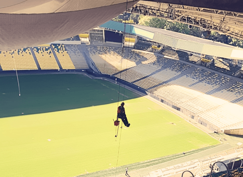 Cordiste suspendu en hauteur pour la peinture du bardage du Stade de la Beaujoire à Nantes