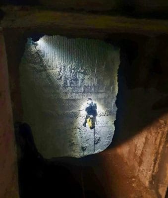 Cordiste réalisant un décroutage à l’intérieur d’une cuve industrielle