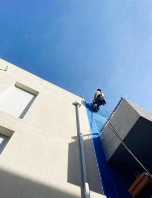 Cordiste descendant le long d’un immeuble sur cordes